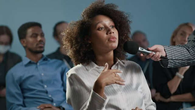 Young Black female manager asking question about presentation or lecture, medium shot