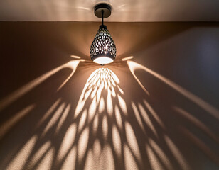 A decorative ceiling lamp casts intricate geometric shadows on the wall, creating a mesmerizing light pattern.