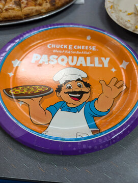 Fun family pizza party at entertainment venue in Oahu, Hawaii with colorful plate featuring cartoon chef