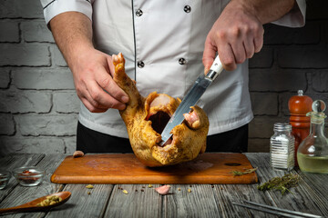 In a cozy kitchen with rustic charm, a skilled chef deftly holds a raw chicken, preparing to carve...