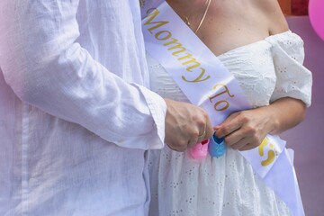 Obraz premium Pregnant woman with sash and baby shoes.