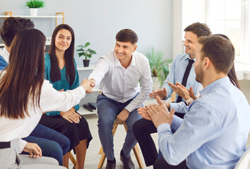 Happy diverse people meet sitting on chairs in circle, enjoy talking on group therapy meeting, discussing addiction, mental health problems, new stuff employees brainstorming on team training activity
