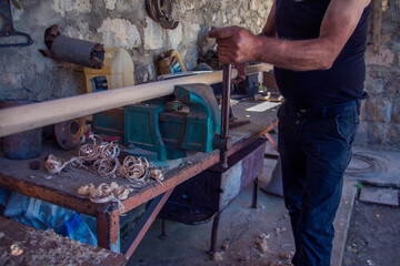 Close up of a carpenter planing a plank of wood with a hand plane