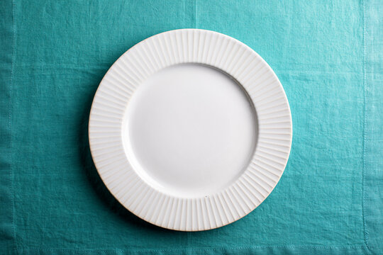 white plate on aqua linen , overhead
