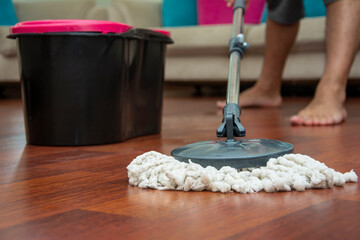 Front view of unrecognizable person with cleaning mop on parquet