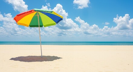 Colorful beach umbrella casting a shadow on pristine sand under a bright blue sky with fluffy clouds evoking a sense of relaxation and joy
