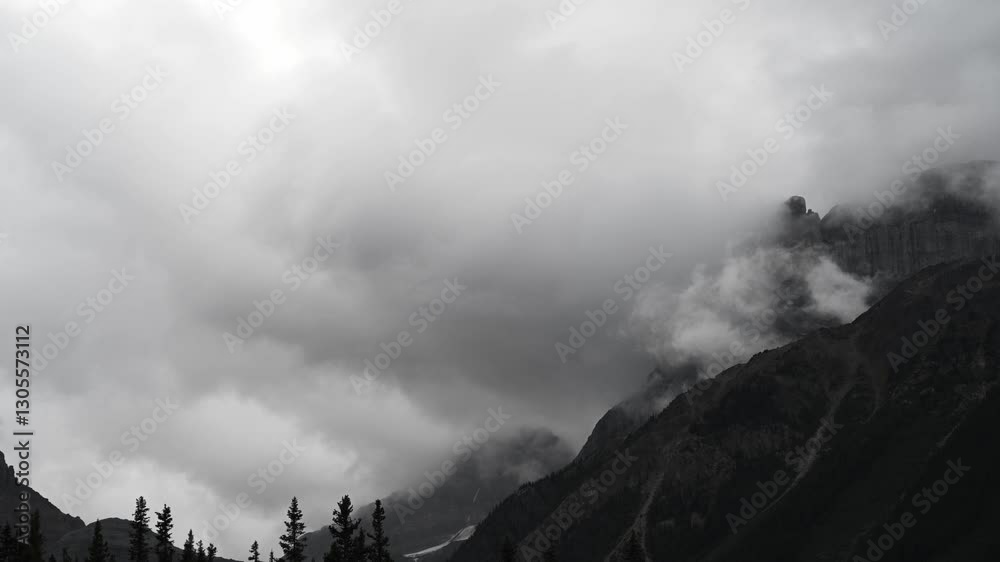 Canvas Prints timelapse of blowing white and grey storm clouds moving between mountains above a forest