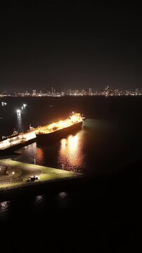 Cinematic aerial view from a drone at night on the Amador Causeway in Panama City, Vertical 4K Video