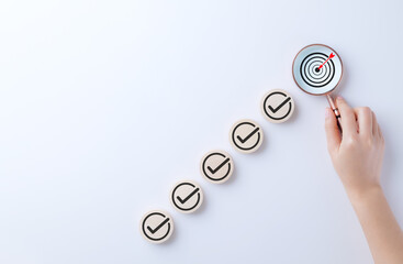 Business strategy planning and quality management concept. Magnifying glass focuses on target icon...