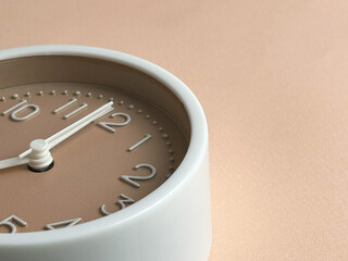 White alarm clock on a colored background. Fashionable minimalist style. Time, business and technology concept. Flat composition. View from above 