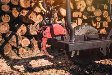 Old forestry tractor loaded with logs. Forestry tractor or forestry tractor for harvesting wood. Wood warehouse. Log pile trunk.