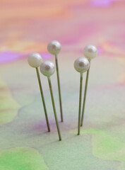 Five sewing pins together forming a circle