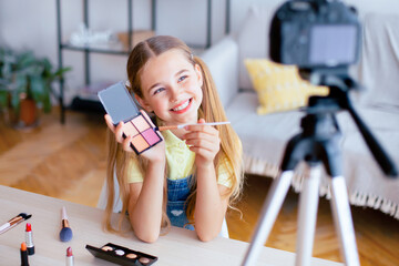 Beauty Blog. Young teenage girl recording vlog about cosmetics and makeup, showing her palette to...
