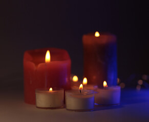 Soft focus. blur Burning candles in black dark. Evening night Light and shadow background. Minimalist still life.