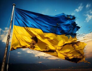 Tattered and war-torn Ukrainian flag flying from a flag pole.