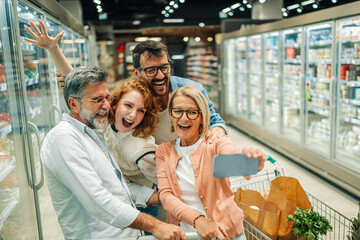 Cheerful family taking a selfie while grocery shopping in supermarket