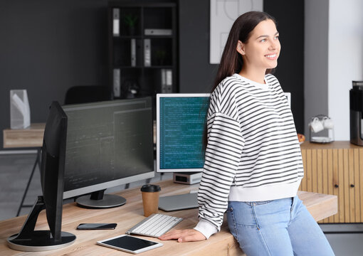 Pretty young female programmer in office