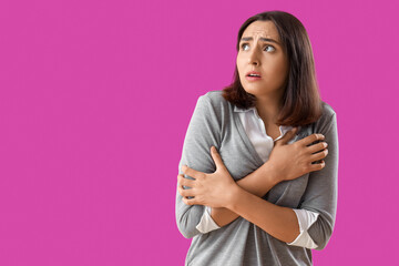 Obraz premium Beautiful young afraid woman on purple background