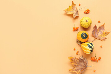 Autumn composition with pumpkins, viburnum and leaves on orange background