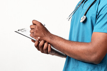 Close up of African American doctor holding folder and filling documents, side view, empty space