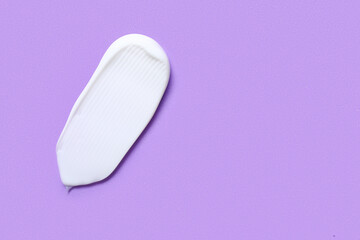 Sample of cosmetic cream on lilac background
