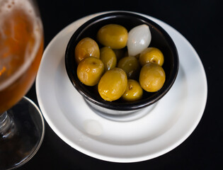 Green olives with pits in bowl with pickled onions