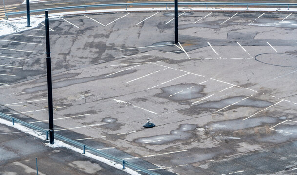 Massive empty parking lot aerial view. Empty aerial view of parking lot for cars Helsinki area in Finland, snowed in Northern European parking on wet and cold asphalt