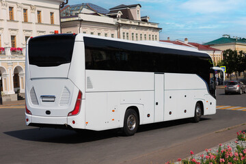 Naklejka premium large tourist bus moves through city center