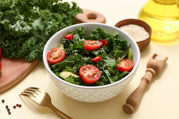 Bowl of tasty kale salad with tomatoes, avocado and sesame seeds on color background