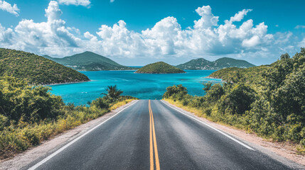 Scenic coastal highway curving along turquoise waters under a bright blue sky with white clouds, perfect for travel and adventure