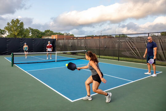 Female Pickleball Player Returns Ball