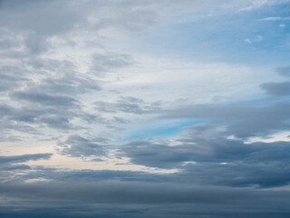 Obraz premium The sky is cloudy and the sun is not visible. The clouds are white and grey. The sky is blue and the clouds are scattered