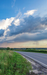 Road with a cloudy sky in the background