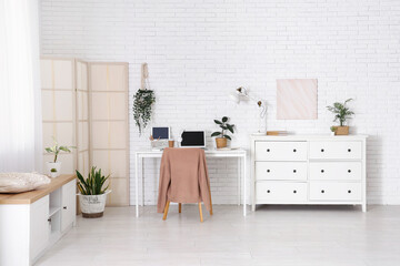 Interior of office with workplace, folding screen and commode