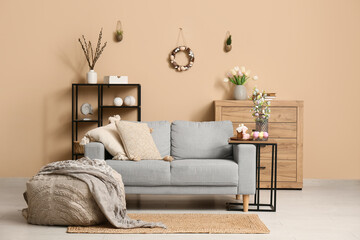 Interior of living room decorated for Easter with sofa, table and pouf