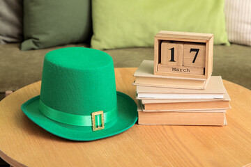 Cube calendar with date of St. Patrick's Day and Leprechaun's hat on table in living room, closeup