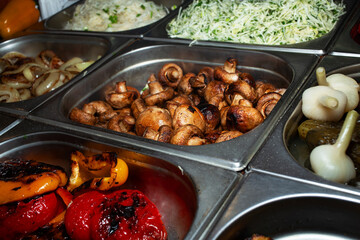 Varied assortment of hot ready-made dishes cooked on the grill. Fast food. Street food to go. Vegetarian menu.