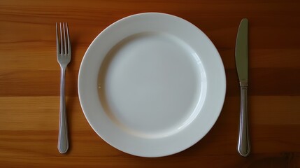 Empty Plate, Fork, and Knife on Wooden Table: A Minimalist Table Setting