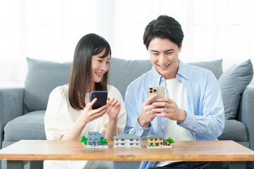 スマートフォンで不動産を探す夫婦