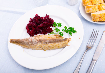 Hot-smoked mackerel fish with boiled beet salad, garnished with fresh parsley