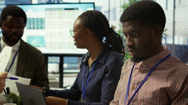 Team of business associates reviewing statistics and infographics on a tablet, working to gather insight for enterprise development. Employees discussing legal changes at a meeting. Camera B.