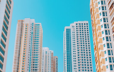 Fototapeta premium Modern high rise buildings against clear blue sky, showcasing urban architecture and design