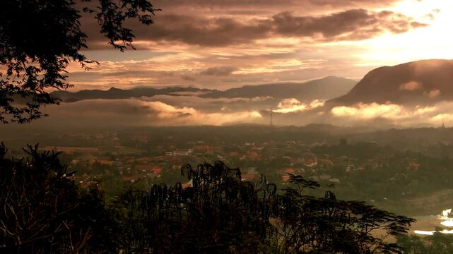 Un paysage montagneux baign&eacute; de lumi&egrave;re dor&eacute;e avec des nuages flottant au cr&eacute;puscule