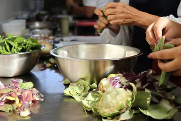 Chefs cleaning artichokes in restaurant kitchen for culinary creation