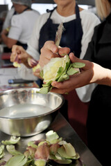 Chefs cleaning artichokes in a cooking class