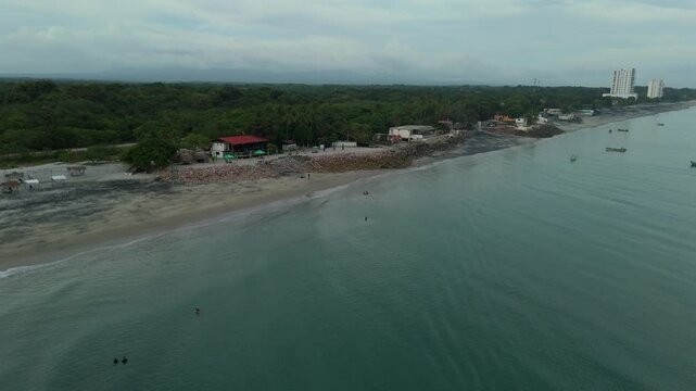 Aerial cinematographic view from a drone along the coast of Rio Hato with cloudy sunset, on the beach of Farallon in the Panamanian Pacific from Panama, 4K Video