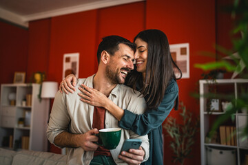 romantic couple at affection hug and smile at home while drink coffee