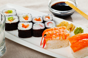 Fresh sushi maki and nigiri served on white plate with wasabi and soy sauce
