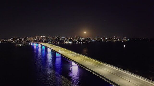 Drone of downtown Sarasota Florida at night over Ringling Causeway Bridge