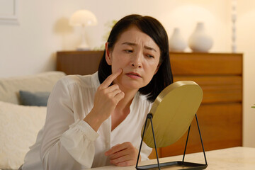 ほうれい線に悩む50代の女性　夜のリビング